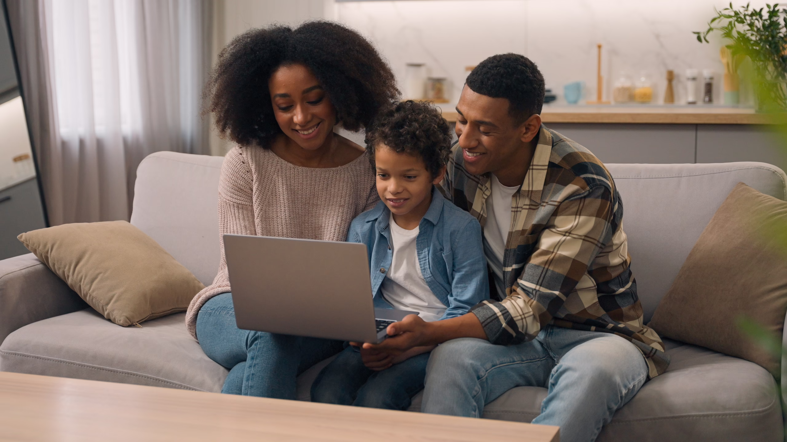 Happy family reviewing mortgage options together on a laptop at home