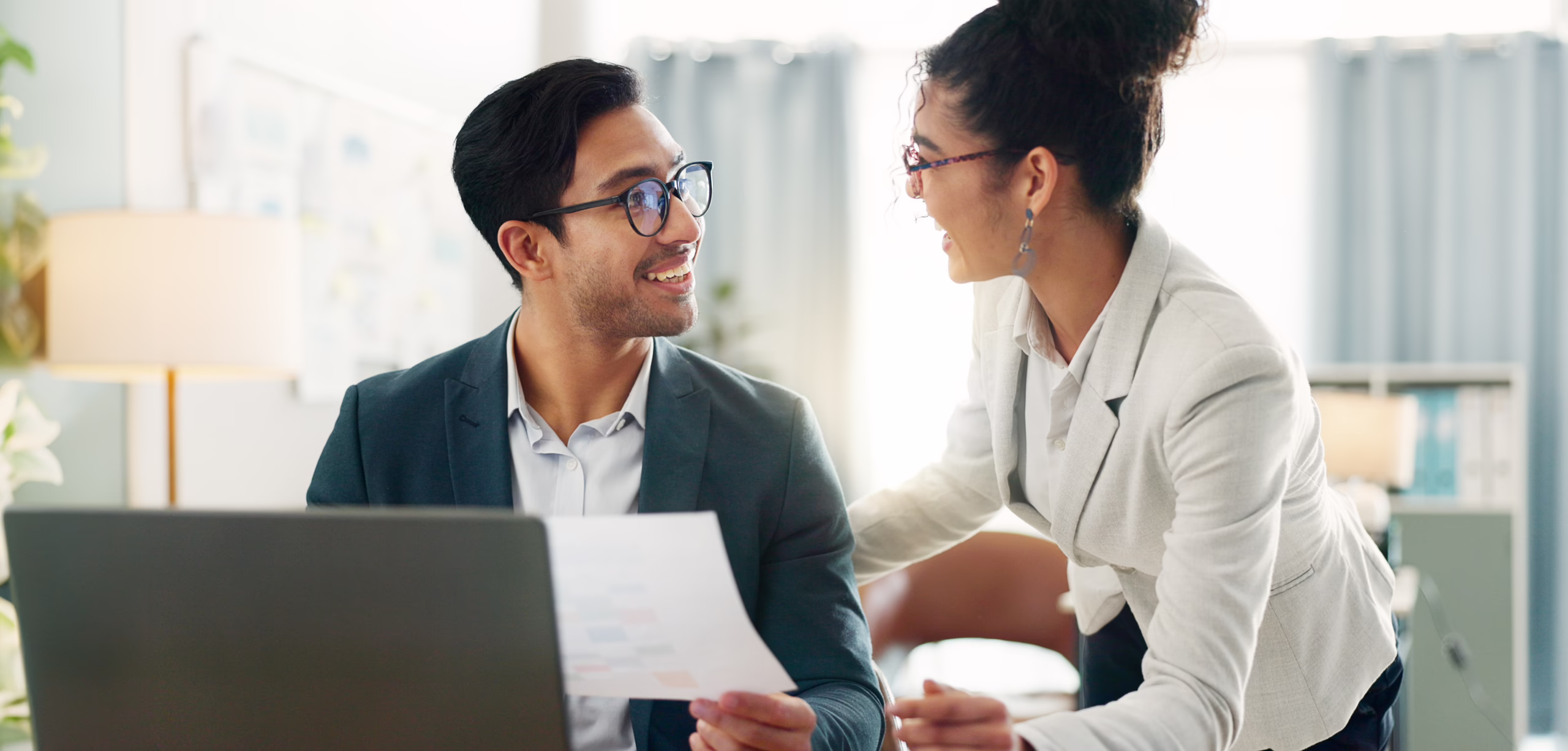 Happy client with her loan officer reviewing numbers